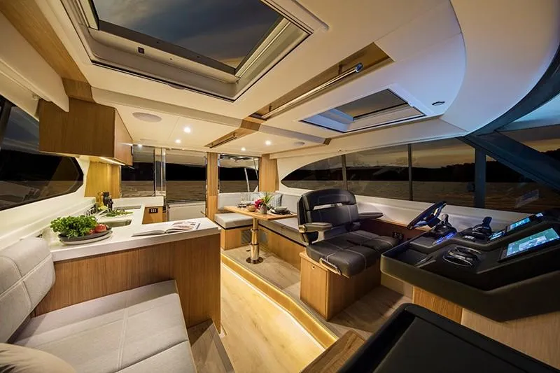 Slide: The Image of 2024 Riviera 395 SUV luxury yacht interior with modern kitchen and captain's chair. - 12