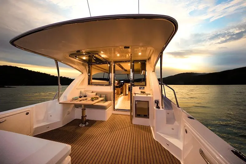 Slide: The Image of 2024 Riviera 395 SUV luxury yacht interior at sunset on the water. - 8
