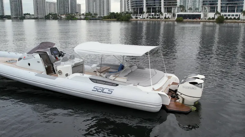 Slide: The Image of 2014 SACS Strider 13 boat docked on calm water with cityscape background. - 17