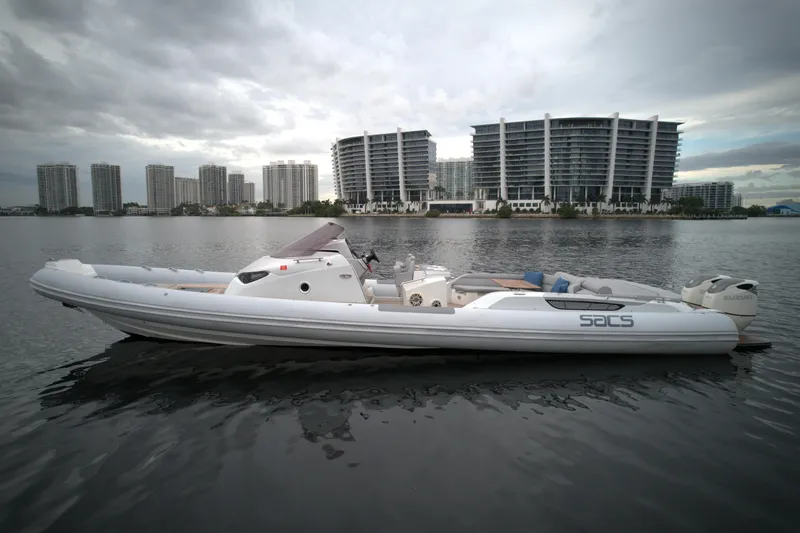Slide: The Image of 2014 SACS Strider 13 boat on calm water with cityscape background. - 3