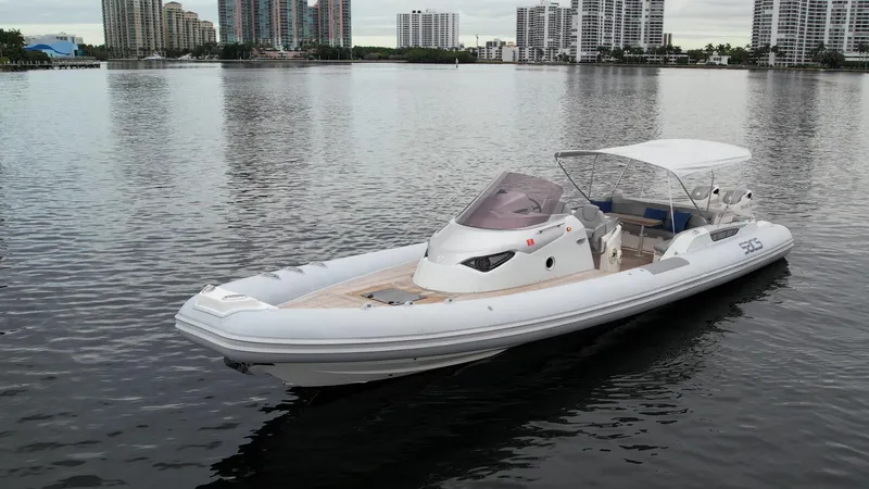 Slide: The Image of 2014 SACS Strider 13 boat on calm water with city skyline in the background. - 35