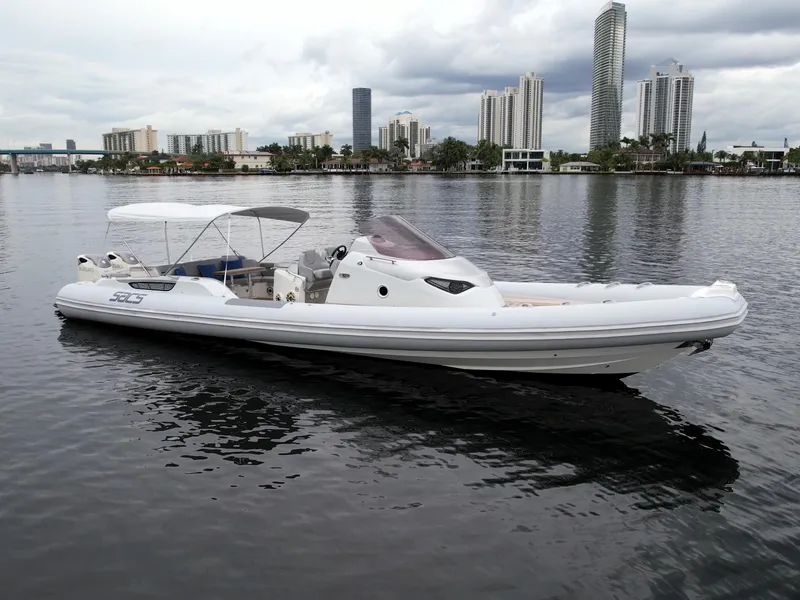 Slide: The Image of 2014 SACS Strider 13 boat on calm water with city skyline background. - 46