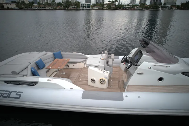 Slide: The Image of 2014 SACS Strider 13 luxury boat with spacious deck and seating on calm water. - 8