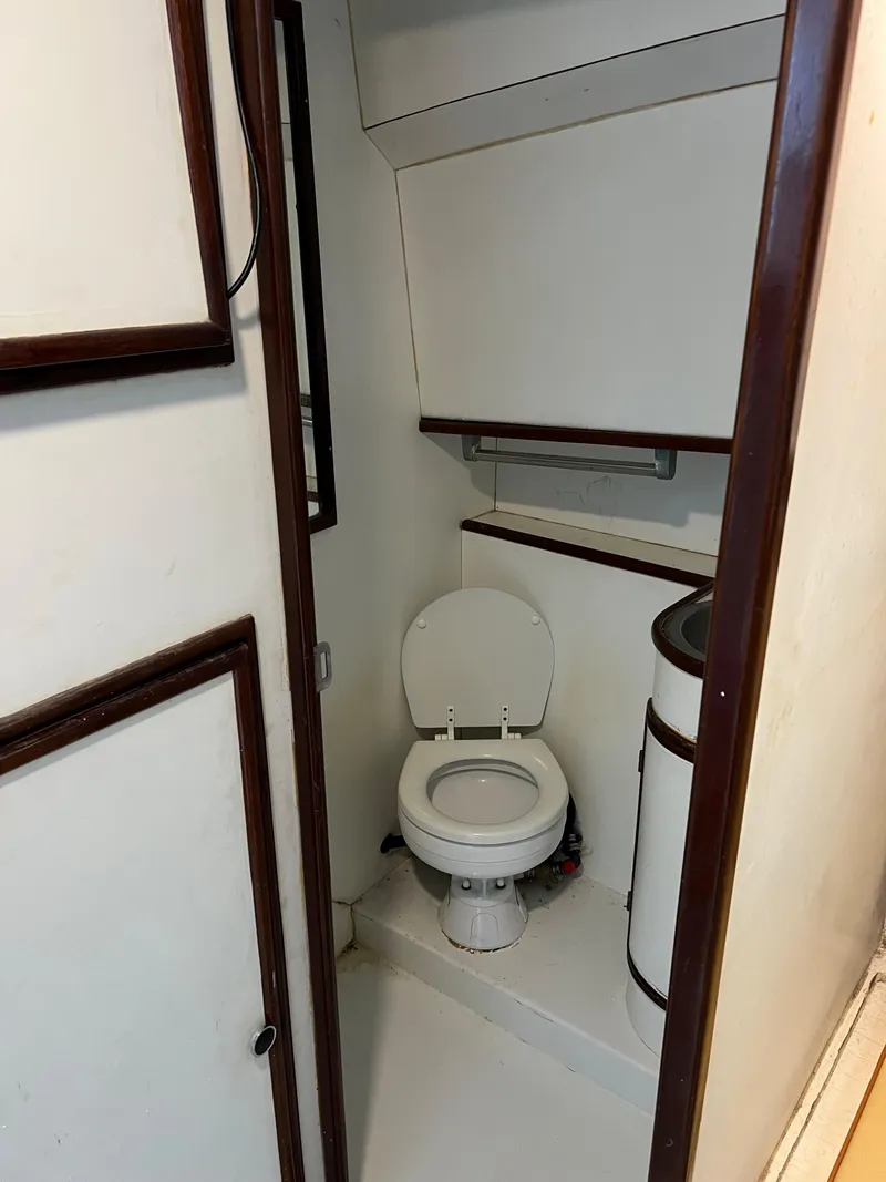 Slide: The Image of 1985 Custom Mabry Edwards boat bathroom with toilet and storage. - 14