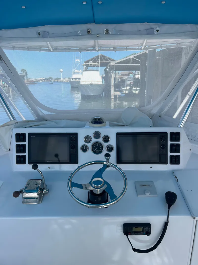Slide: The Image of Boat helm of a 1985 Custom Mabry Edwards with dual screens and marina view. - 8