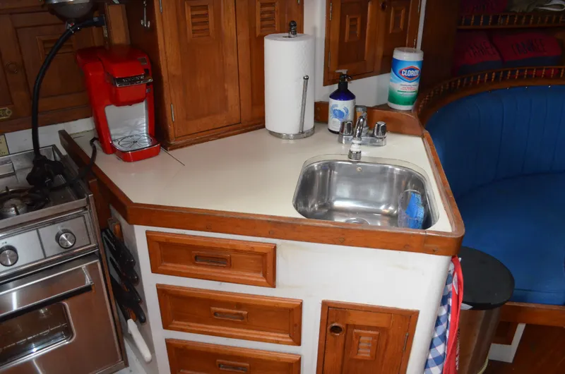 Slide: The Image of 1977 Cheoy Lee 41' Offshore yacht galley with sink, stove, and wooden cabinetry. - 16