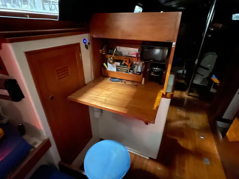 Slide: The Image of 1977 Cheoy Lee 41' Offshore yacht interior with wooden desk and storage area. - 20