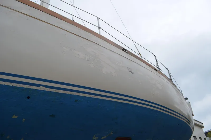 Slide: The Image of 1977 Cheoy Lee 41' Offshore sailboat with blue and white hull, docked under cloudy sky. - 3