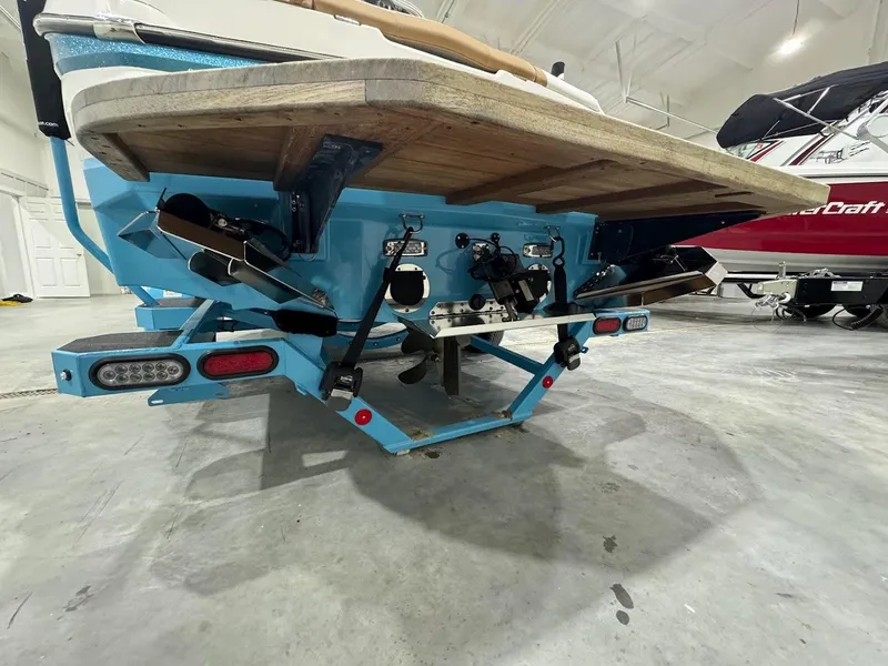 Slide: The Image of 2022 MasterCraft NXT24 boat rear view in a showroom. - 1
