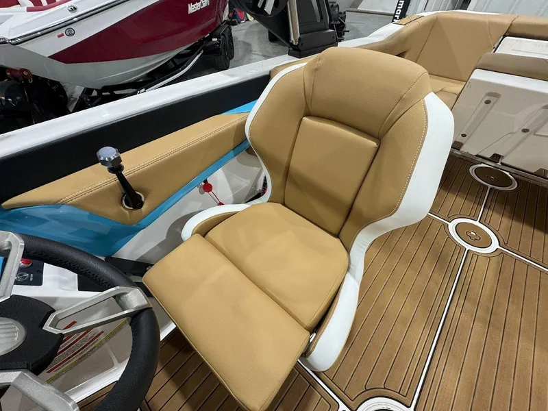 Slide: The Image of 2022 MasterCraft NXT24 boat interior with tan captain's chair and teak flooring. - 14