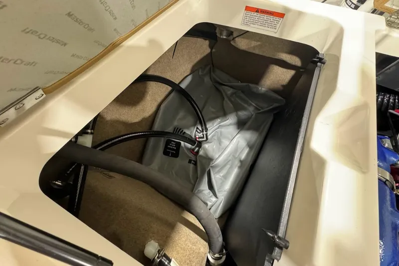 Slide: The Image of 2022 MasterCraft NXT24 storage compartment with ballast bag and hoses. - 21