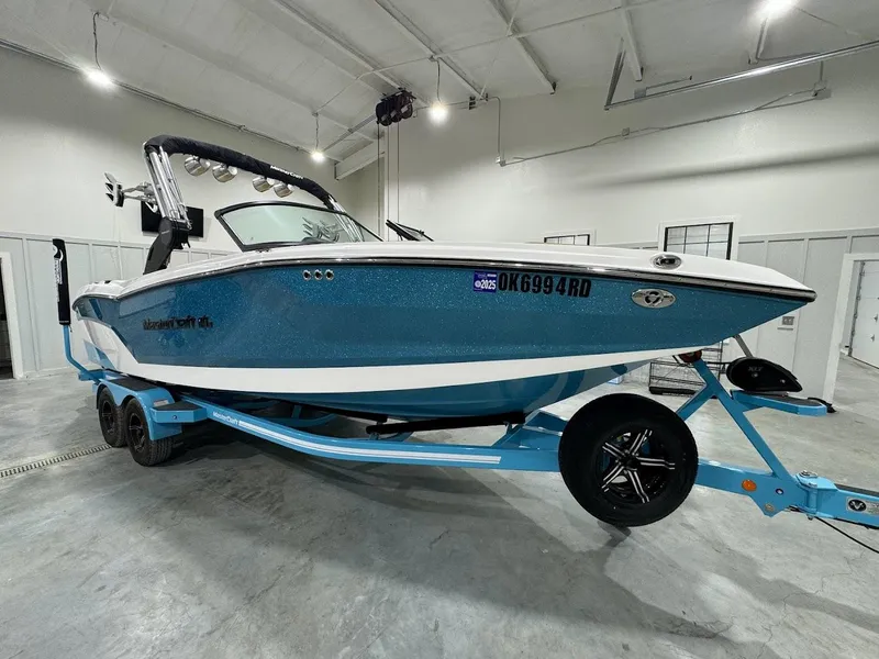 Slide: The Image of 2022 MasterCraft NXT24 boat on a trailer in a garage. - 6