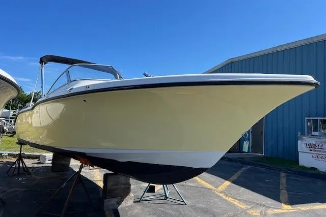 Slide: The Image of 2020 Key West 239 DFS boat on stands, yellow hull, blue sky background. - 4