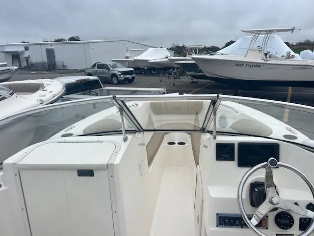 Slide: The Image of 2020 Key West 239 DFS boat interior with steering wheel and dashboard, parked in a marina. - 9