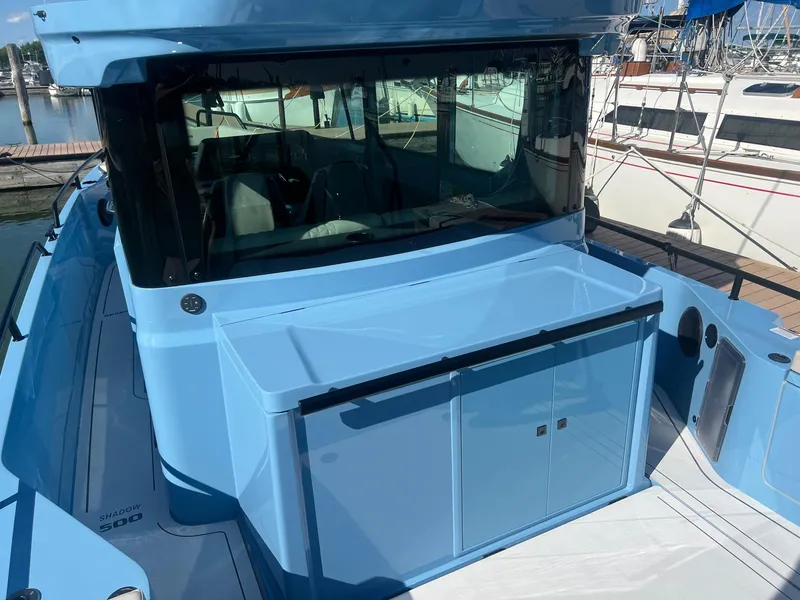 Slide: The Image of 2023 BRABUS Shadow 500 Cabin boat docked at marina, showcasing sleek blue exterior. - 11