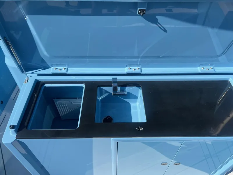 Slide: The Image of 2023 BRABUS Shadow 500 Cabin sink and storage area in blue. - 12