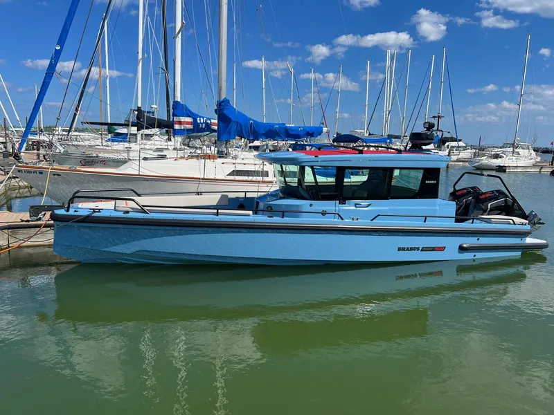Slide: The Image of 2023 BRABUS Shadow 500 Cabin boat docked at a marina with sailboats in the background. - 2