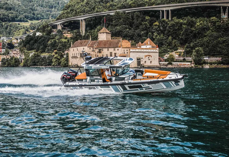 Slide: The Image of 2023 BRABUS Shadow 500 Cabin boat cruising on a scenic lake with a historic castle in the background. - 31
