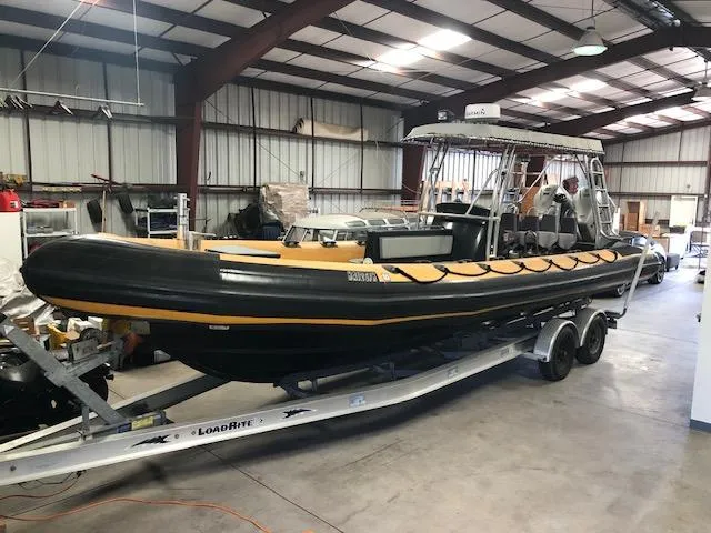 The Image of 2008 Ribcraft 9.0 boat on trailer in warehouse setting. - 0