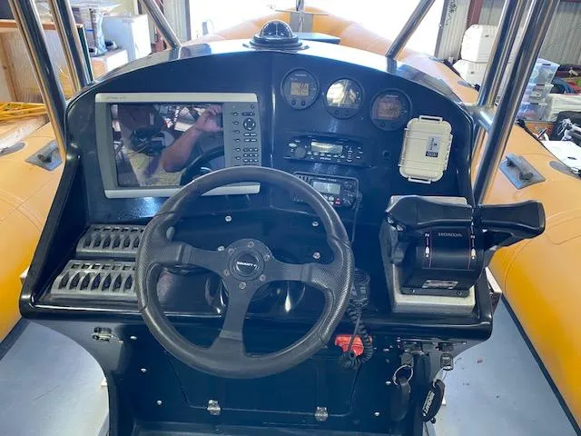 Slide: The Image of 2008 Ribcraft 9.0 boat dashboard with steering wheel, controls, and navigation equipment. - 1