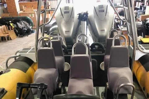 Slide: The Image of 2008 Ribcraft 9.0 boat interior with seating and dual engines in a warehouse setting. - 8