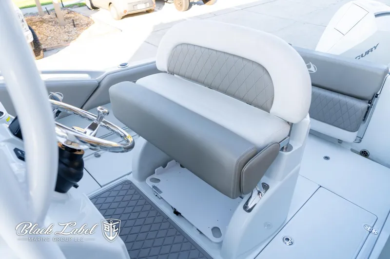 Slide: The Image of 2024 Finseeker 220 FinSeeker boat interior with steering wheel and cushioned seating. - 12