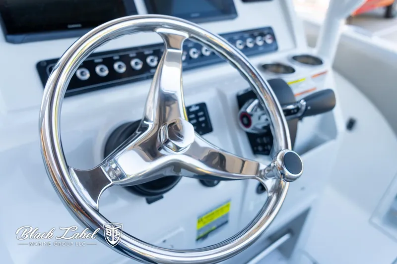 Slide: The Image of 2024 Finseeker 220 FinSeeker boat steering wheel and dashboard controls. - 16