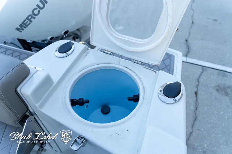 Slide: The Image of 2024 Finseeker 220 FinSeeker livewell with open lid, featuring a Mercury engine in the background. - 25