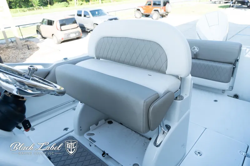 Slide: The Image of 2024 Finseeker 230 boat interior with cushioned seating and steering wheel. - 18