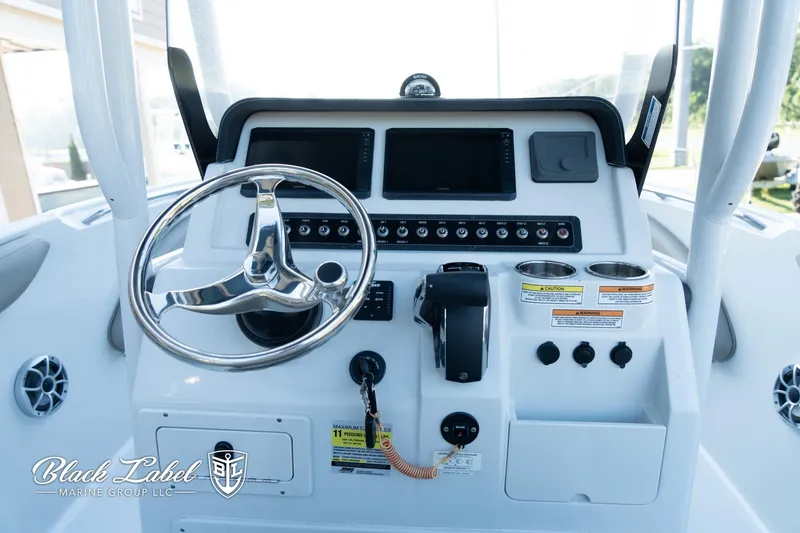 Slide: The Image of 2024 Finseeker 230 FinSeeker boat dashboard with steering wheel and controls. - 19