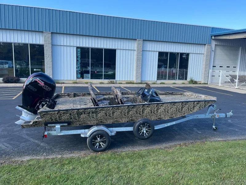 Slide: The Image of 2024 Lowe Outlet 20 boat on a trailer outside a building. - 1