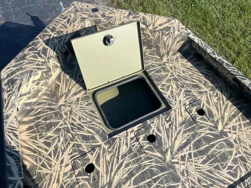 Slide: The Image of 2024 Lowe Outlet 20 boat with open storage compartment and camouflage design. - 14