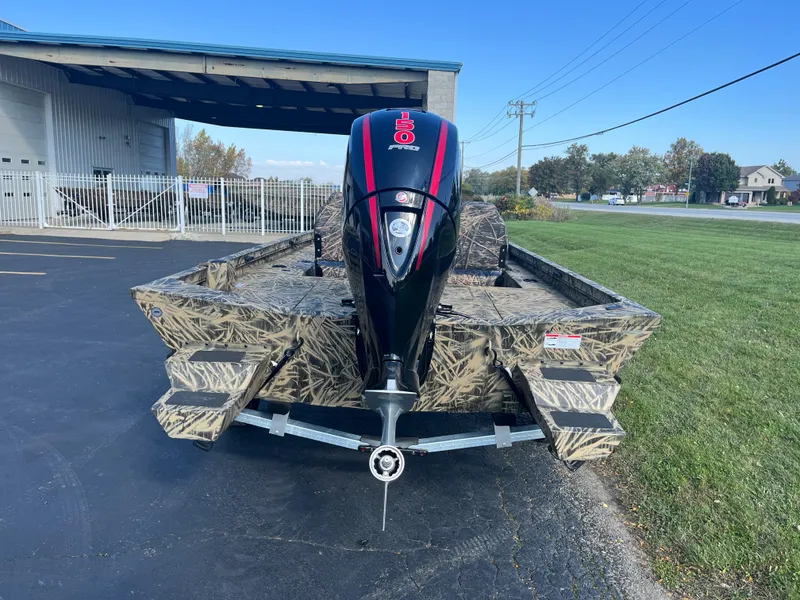 Slide: The Image of 2024 Lowe Outlet 20 boat with camouflage design and powerful outboard motor. - 2