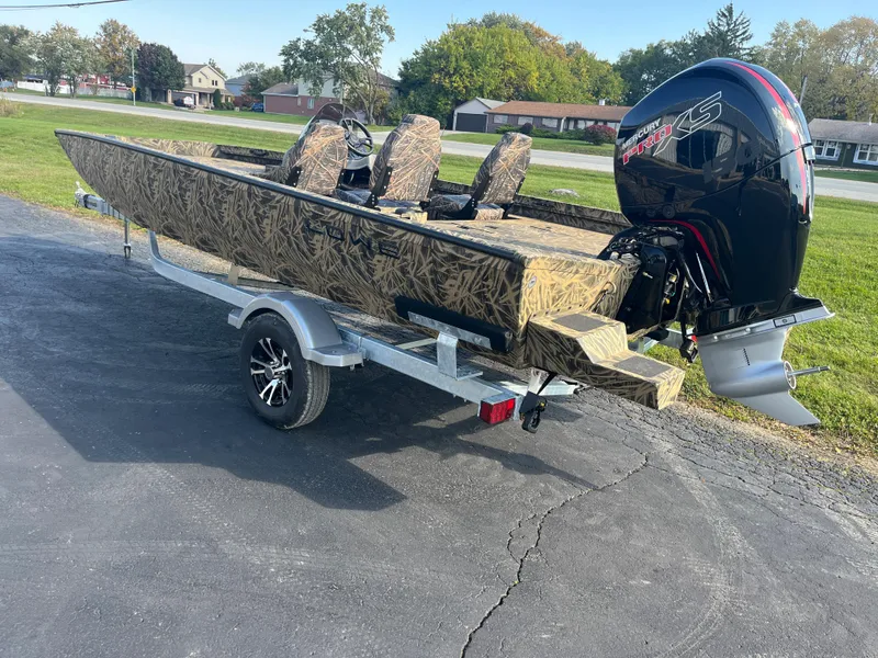 Slide: The Image of 2024 Lowe Outlet 20 boat on trailer with camo design and powerful outboard motor. - 3