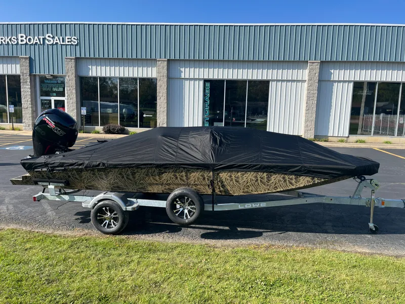 Slide: The Image of 2024 Lowe Outlet 20 boat with cover on trailer outside dealership. - 4