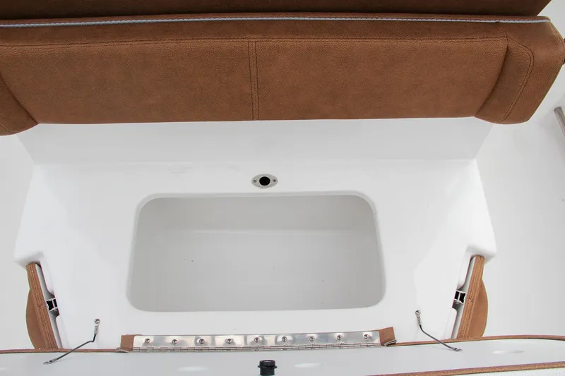 Slide: The Image of 2024 Sea Hunt Ultra 255 SE boat storage compartment with brown cushioned seating. - 18