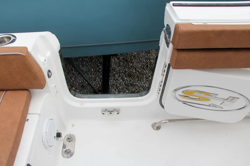 Slide: The Image of 2024 Sea Hunt Ultra 255 SE boat interior with brown seating and open side door. - 24