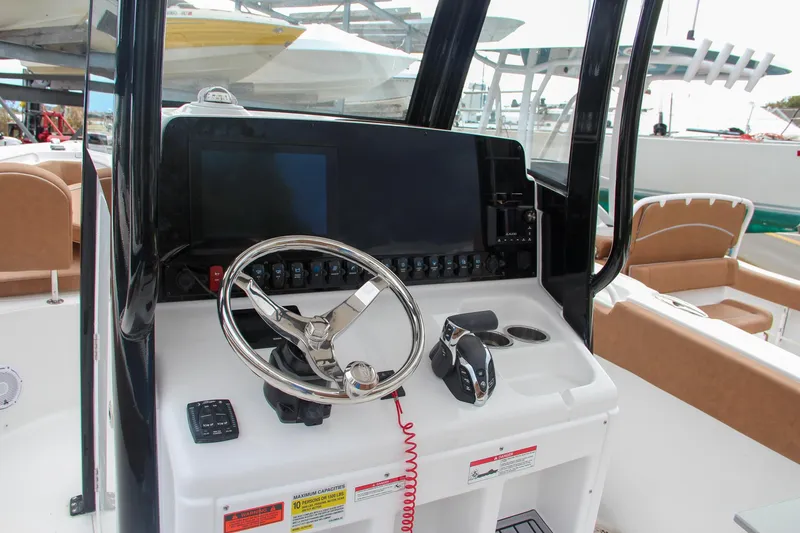 Slide: The Image of 2024 Sea Hunt Ultra 255 SE boat dashboard with steering wheel and controls. - 36