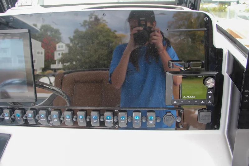 Slide: The Image of Control panel of 2024 Sea Hunt Ultra 255 SE boat with reflection of person taking photo. - 40