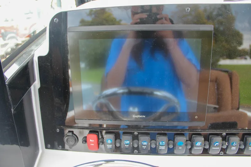 Slide: The Image of 2024 Sea Hunt Ultra 255 SE dashboard with Garmin display and control switches. - 41