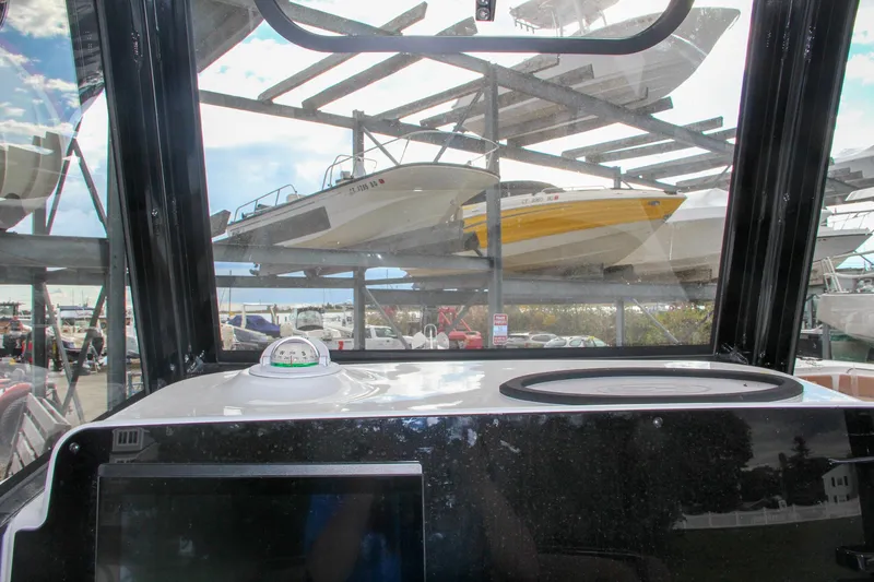 Slide: The Image of View from the helm of a 2024 Sea Hunt Ultra 255 SE boat in a marina. - 42