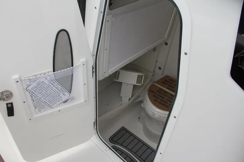 Slide: The Image of 2024 Sea Hunt Ultra 255 SE boat interior with enclosed toilet. - 47