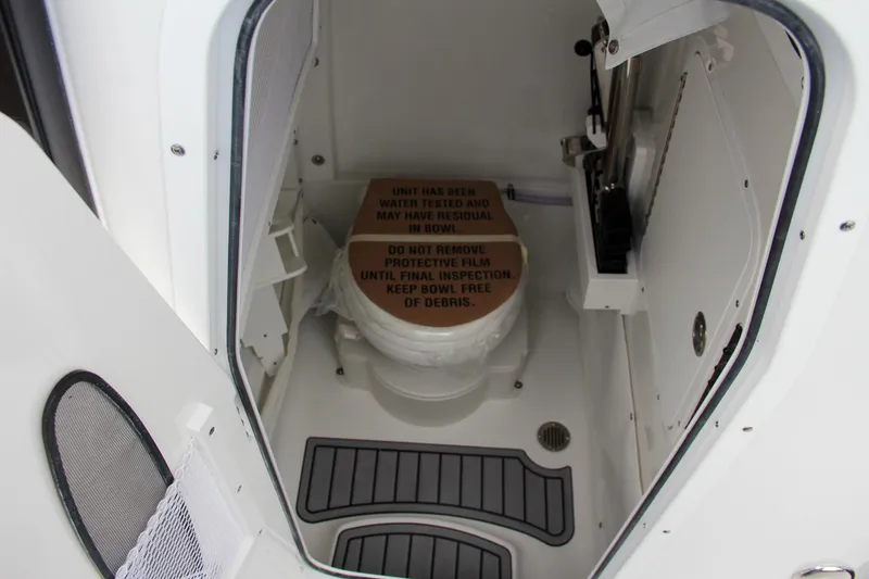 Slide: The Image of 2024 Sea Hunt Ultra 255 SE boat interior with toilet and protective film. - 48