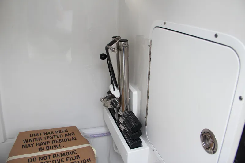 Slide: The Image of 2024 Sea Hunt Ultra 255 SE interior storage compartment with equipment and cardboard box. - 49