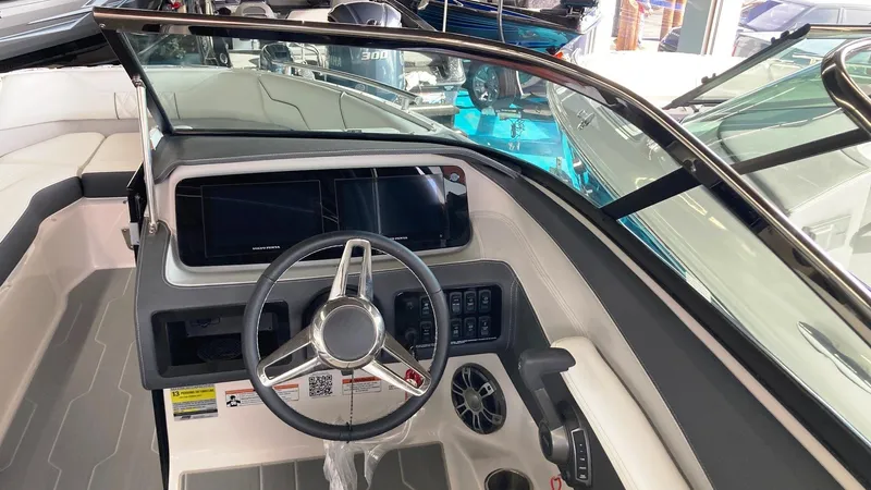 Slide: The Image of 2024 Regal LS4 Surf boat dashboard with steering wheel and control panel. - 9