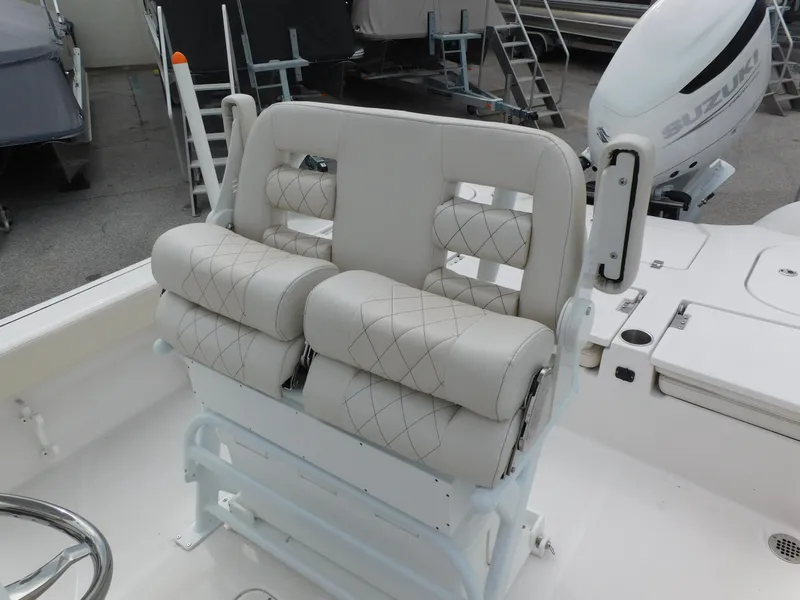 Slide: The Image of 2024 Blue Wave 2600 PureBay boat with cushioned seating and Suzuki outboard motor. - 18