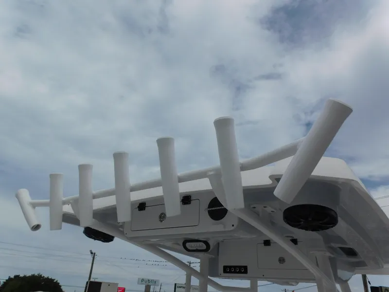 Slide: The Image of 2024 Blue Wave 2600 PureBay boat with rod holders and speakers against a cloudy sky. - 22
