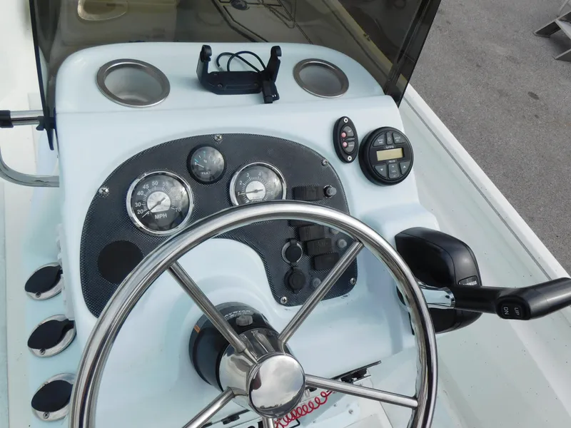 Slide: The Image of 2018 Excel 22'3 Bay Pro boat dashboard with steering wheel and gauges. - 12