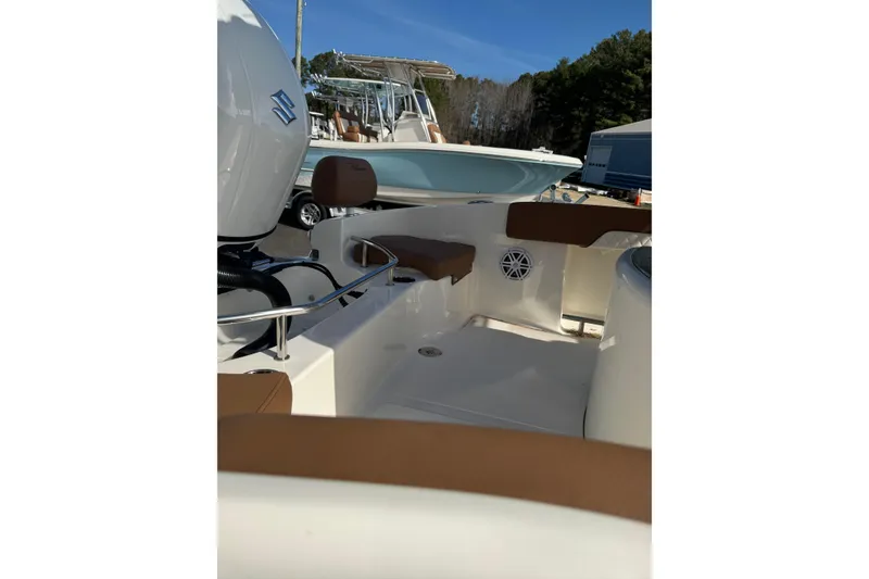 Slide: The Image of 2026 Pioneer 202 Sportfish boat interior with seating and motor, displayed outdoors. - 8