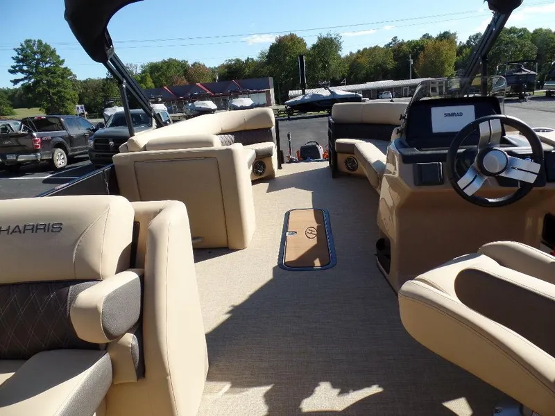 Slide: The Image of 2024 Harris Sunliner 250 boat interior with beige seating and modern dashboard. - 11